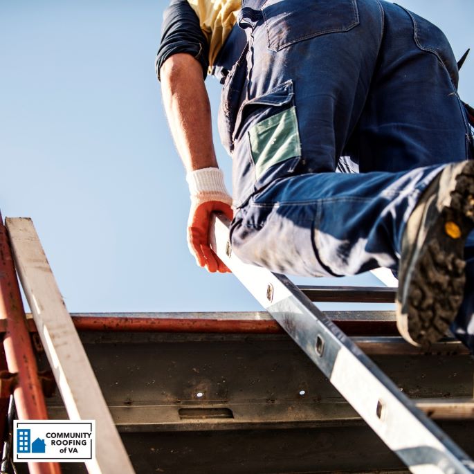 A Community Roofing of VA worker climbing up a ladder to a low slope rooftop